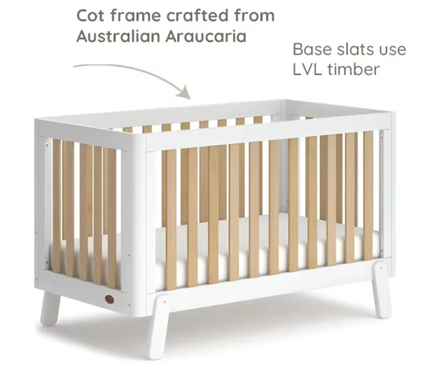 White wooden cot bed with labels pointing to the Australian Araucaria frame and the LVL timber base slats White wooden cot bed with labels pointing to the Australian Araucaria frame and the LVL timber base slats